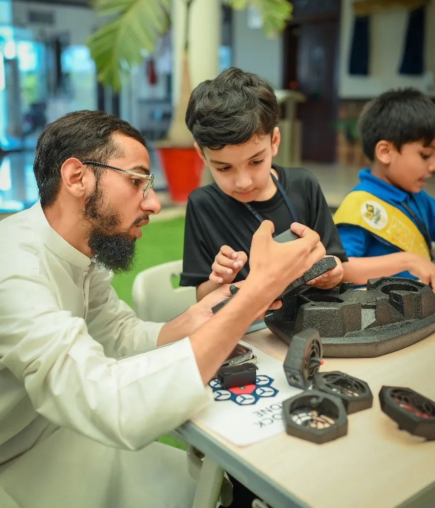 Trainer guiding students through drone assembly