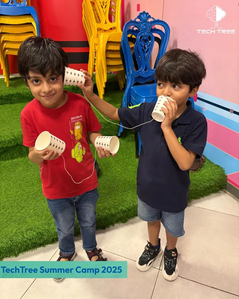 Two students building a string telephone — engineering experiment